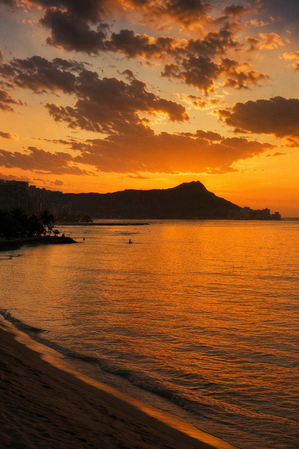 Diamond Head silhouetted at sunset across the water in Honolulu, Hawaii